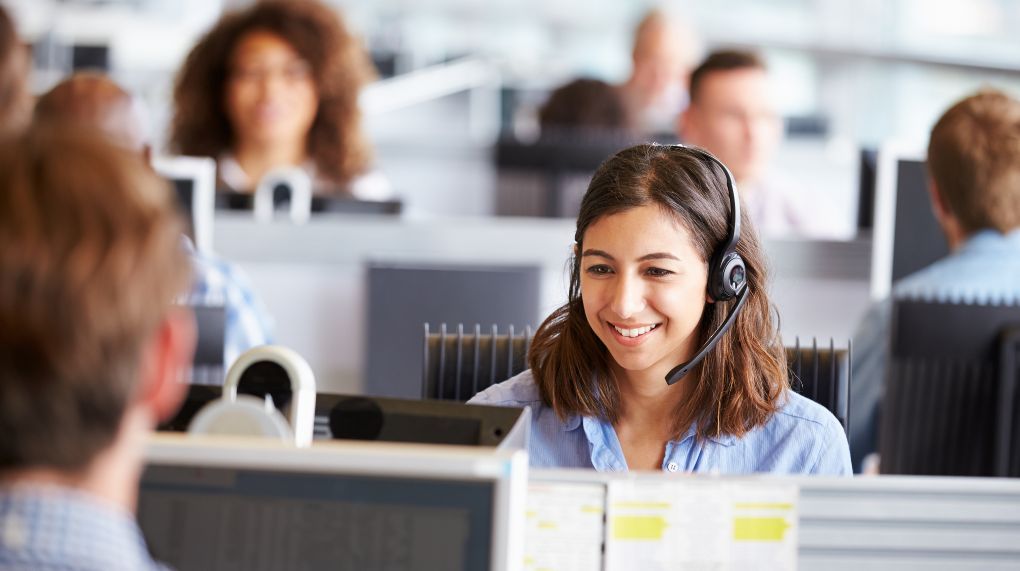 Woman in call center answers phone and benefits from call whispering notification