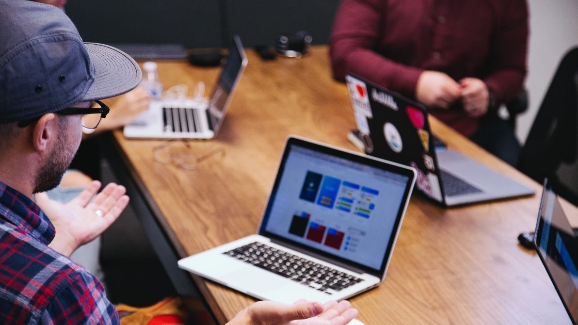 Man looks at computer in a meeting