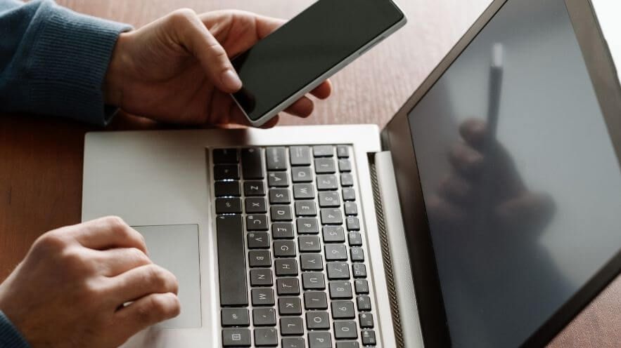 person using 2FA with a laptop and cell phone